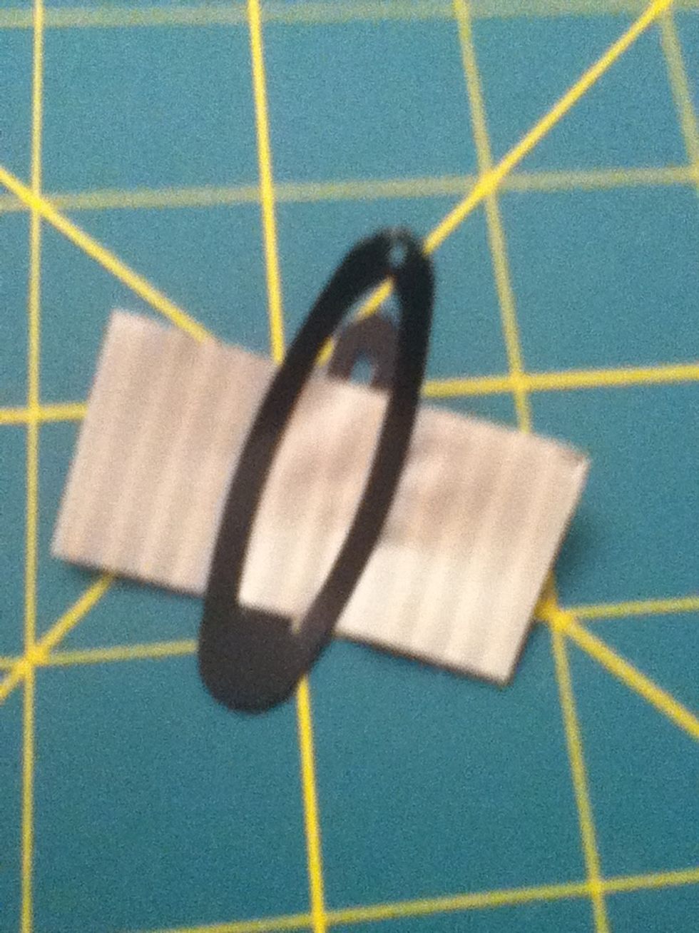 Now get your hair clip and put a small piece of tape on it like this.
