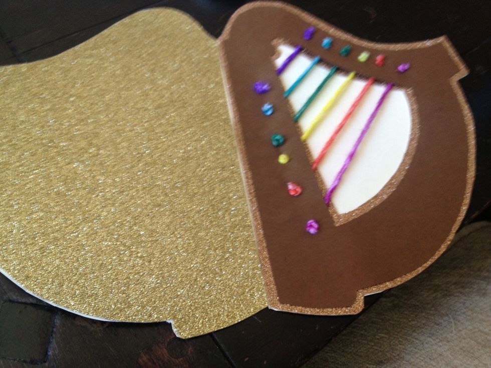 now glue the harp to the front of the card (I used my gold "mess up" for the back!) trim the excess cream paper and set beneath heavy object to dry.