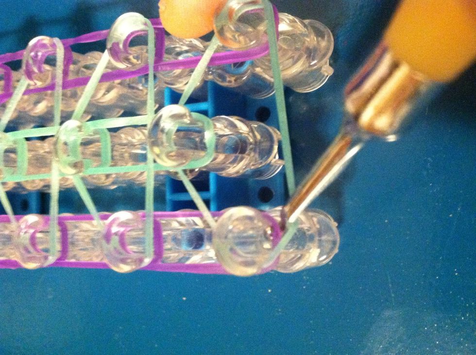 Now go under the triangle grab the purple band and loop it to the next peg