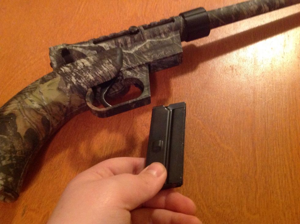 Now grab one of the magazines and insert it into the slit in front of the trigger.