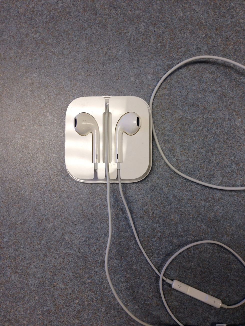 Now grab the left EarPod's cord and start wrapping it from the bottom towards the right. Then go up and around until you get to the top-center place holder.