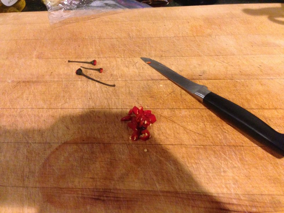 Now, grab your haba\u00f1ero peppers and chop them up too. Make sure to avoid touching your eyes or else your eyes will burn. Put the chopped up peppers in the blender.