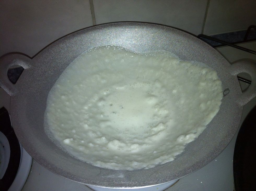 Now heat the kadai, grease it with oil. Ladle a spoon of the secondary batter.Hold both handle of the wok.swivel it at one direction. It will be thin in the edge and thick in the centre. Place a lid.