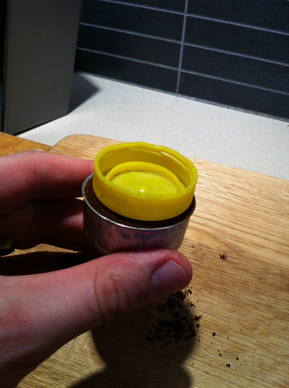 Now. Here's my secret to a consistent brew. I GENTLY tamp the coffee to a perfectly level surface using a bottle cap. The purpose of this is to GENTLY compact the coffee so it will extract evenly.