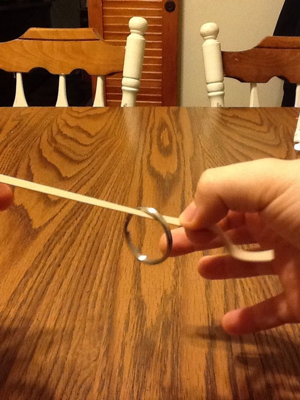 Now here's the secret put a 1/4 of the rubber band into your right hand hiding it from the audience