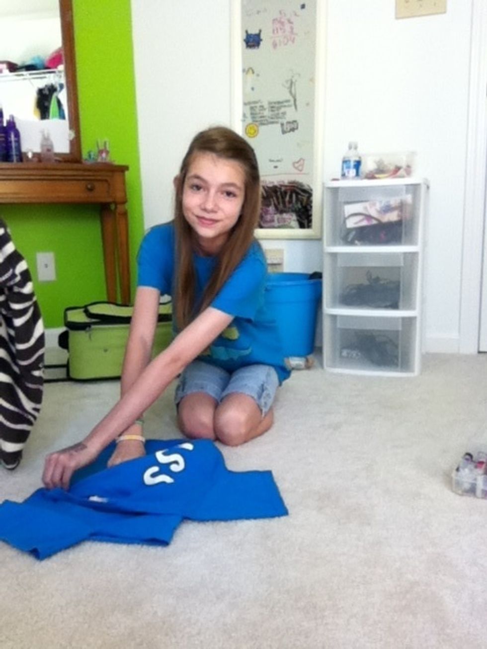 Now heres the tricky part! Bring your left hand around and pinch at the bottom of the shirt. This pinch should be alligned with the first one.