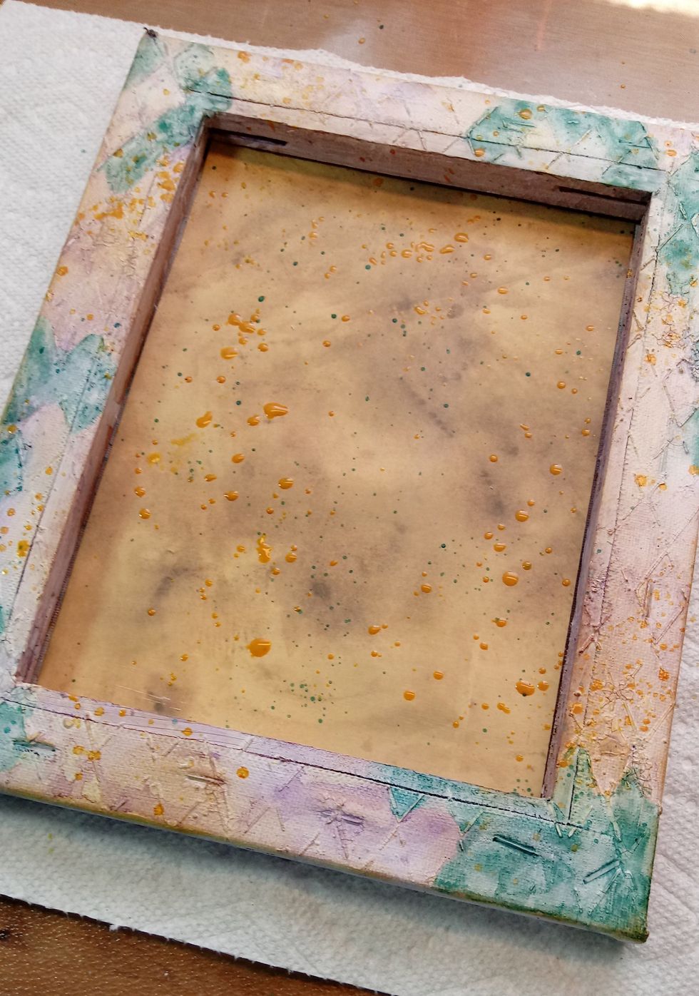 Now I chose to glue a grungy patterned cardstock to inside of my canvas and douse it with more splatters of Amber paint. I love the golden look.