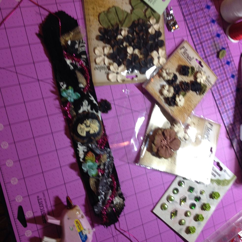 Now I grabbed all my flowers and brads and started gluing them on. Remember only the front 4-5 inches will show so focus your best parts there
