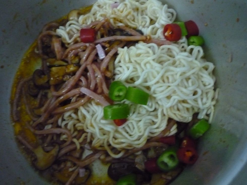 Now i put noodle and peppers. You can use a packet of instant noodle. It tastes really nice. Just put it in boiling water for 2 minutes and yes its ready for this stir- fried noodle dish.