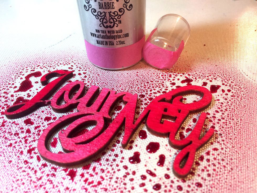 Now, I spray the "Journey" wood piece and spray it with Barbie Colorations Spray.