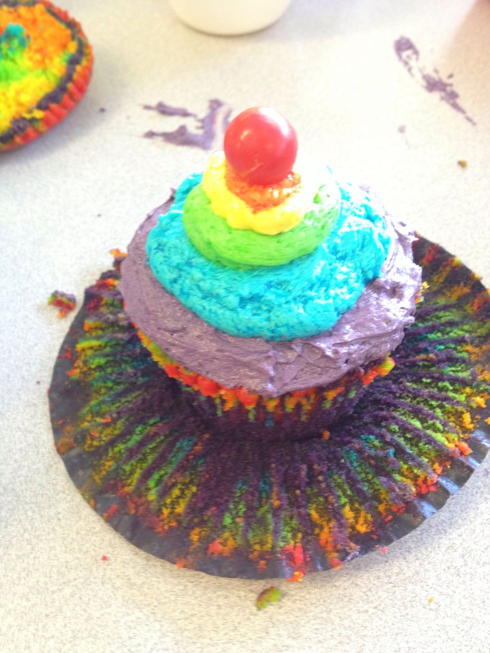 Now ice the bottom layer of the cupcake in a purple icing you have prepared before, continue to layer the cupcake going from the bottom (purple, blue, green, yellow, orange)