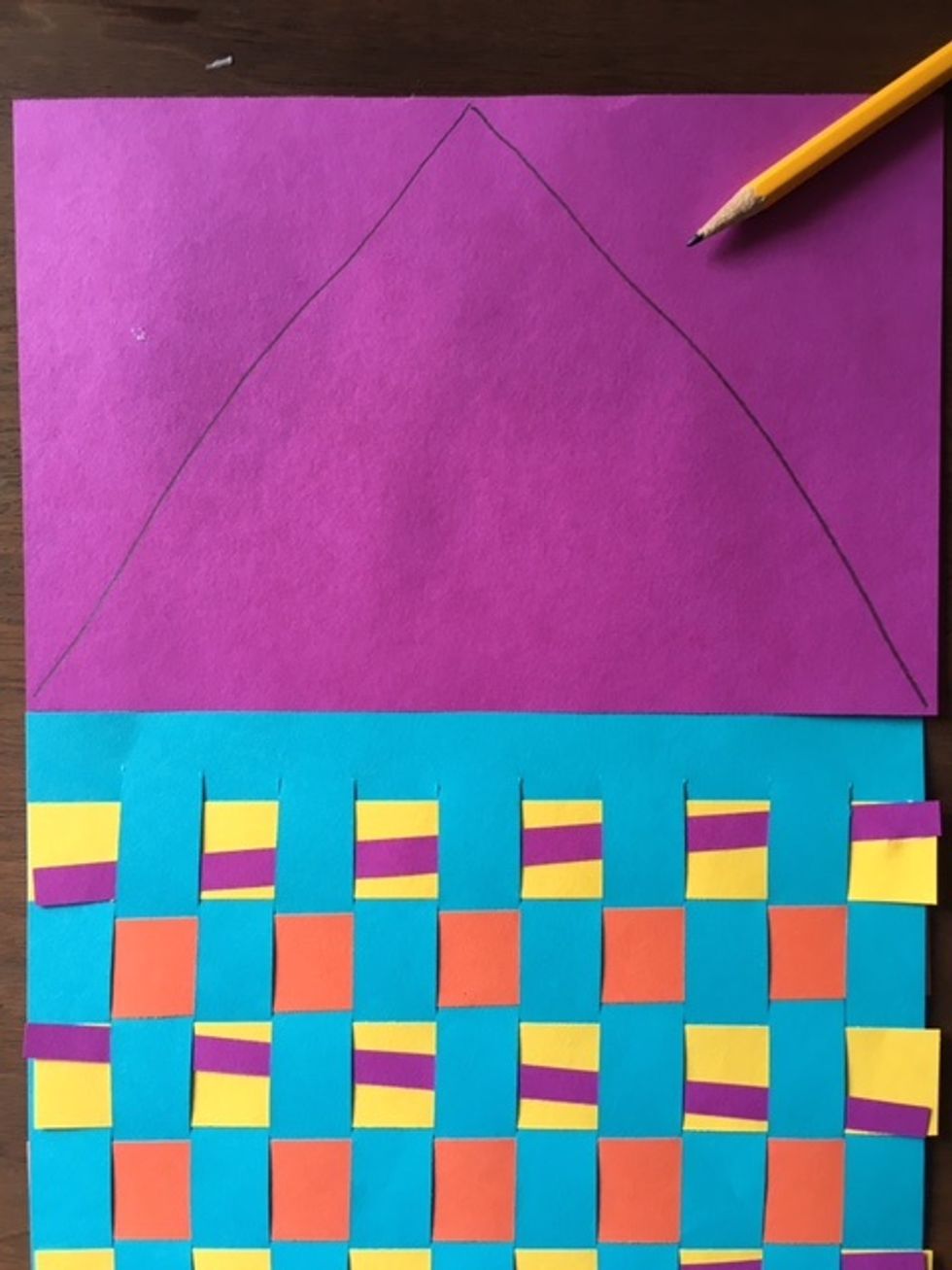 Now, it's time to add some shapes and colors to turn our weaving into a rocket! Draw a triangle shape on another piece of paper for the top of the rocket. Make sure you draw it large enough.