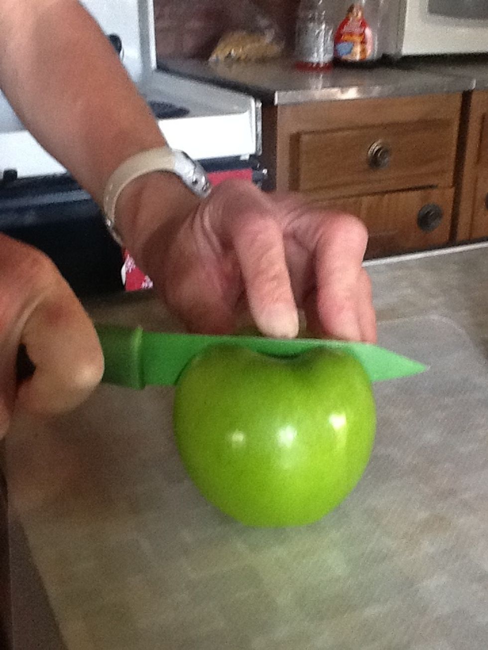 Now it's time to cut the apple. Start by cutting it in half. Make sure your mom (or dad) helps with the cutting.