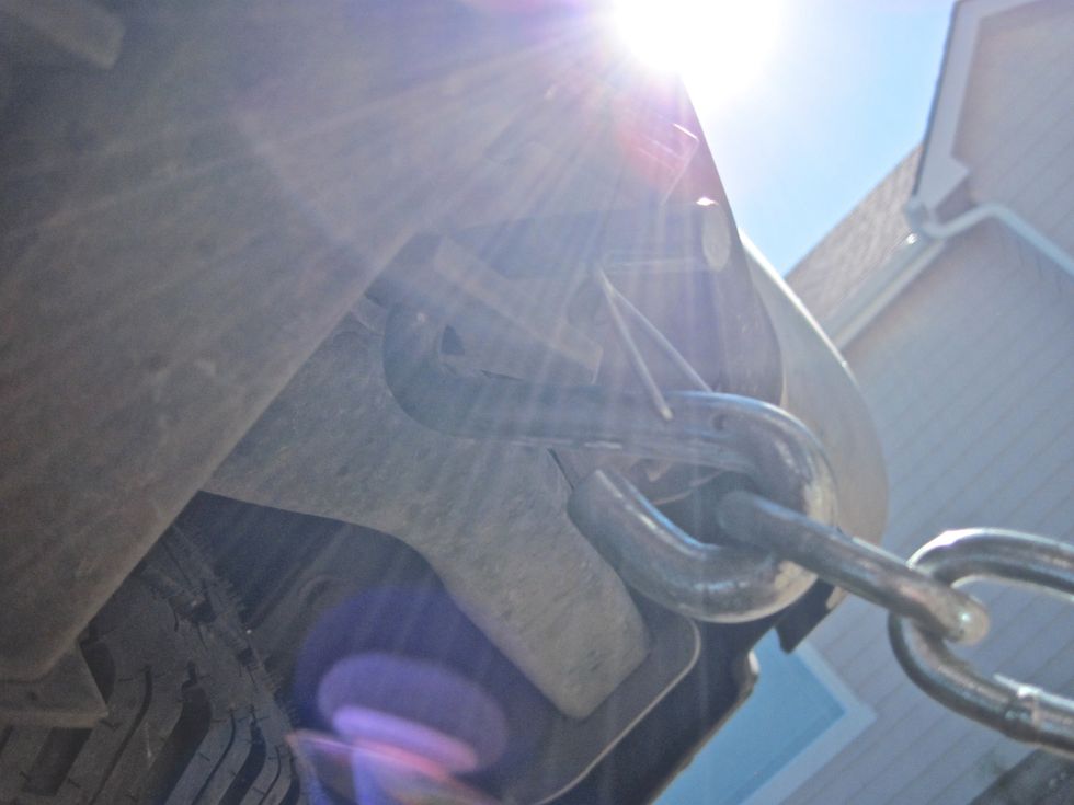 Now it's time to get a little dirty. Take one of the chains and hook it underneath the tow vehicle on a steel tag with a hole in it. Bend under and look for the right spot. Hook up both chains.