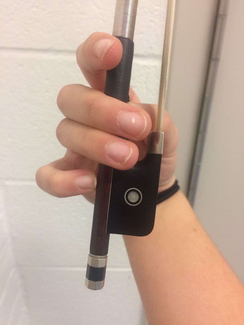 Now it's time to pick up the bow! Put your bow in between your thumb and middle and ring fingers. Your pinky should be standing up and your pointer should be resting on the bow above the other fingers