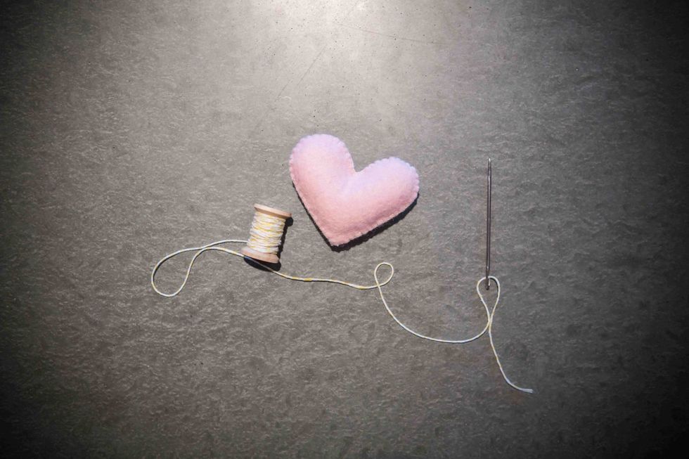 Now it's time to string all of the hearts together. Take your baker's twine and large needle. Thread the twine through the eye of the needle.