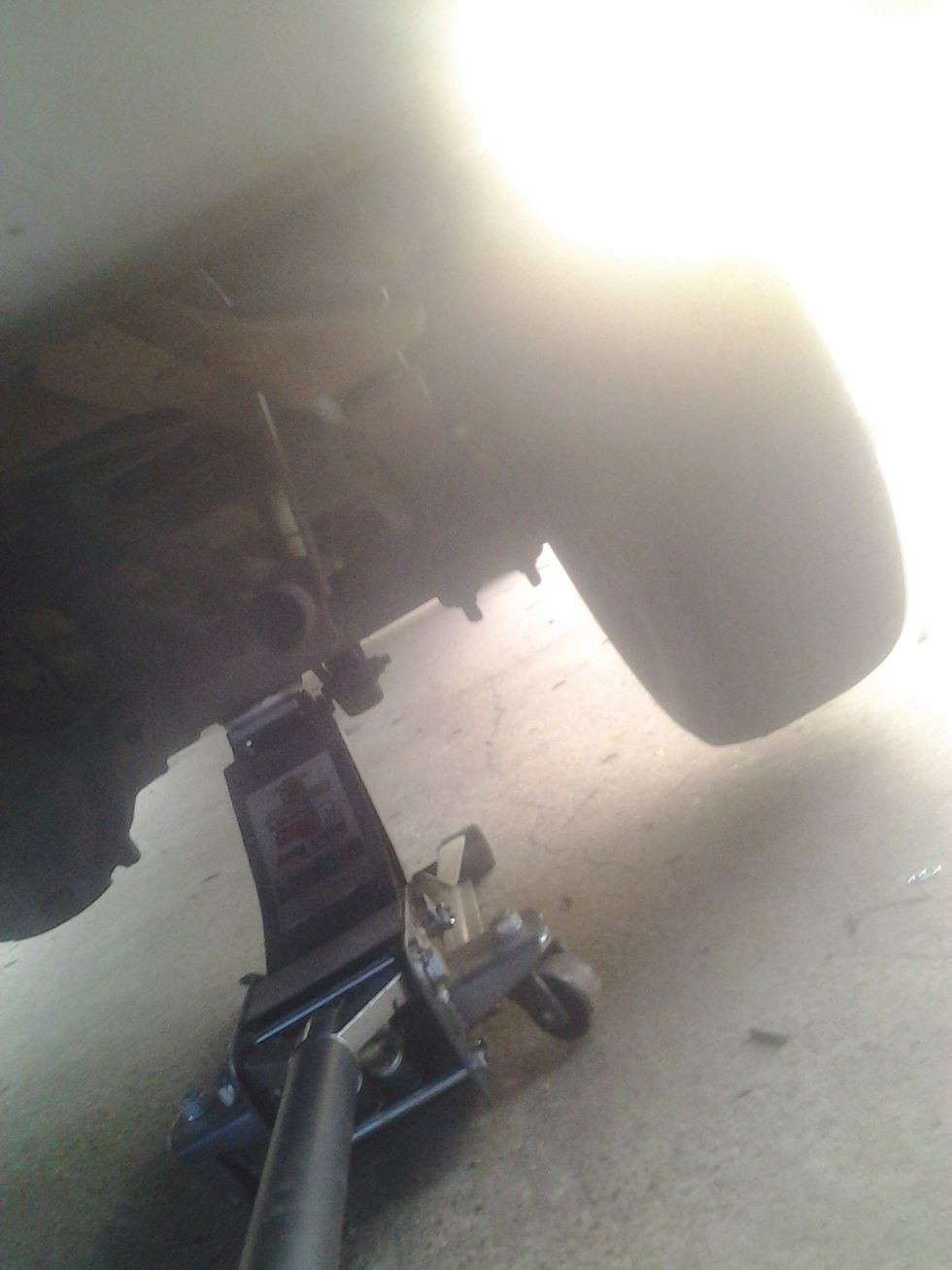 Now jack it up under the axle or frame if you have a car, make sure it's in a good place so it doesn't slip off and fall.