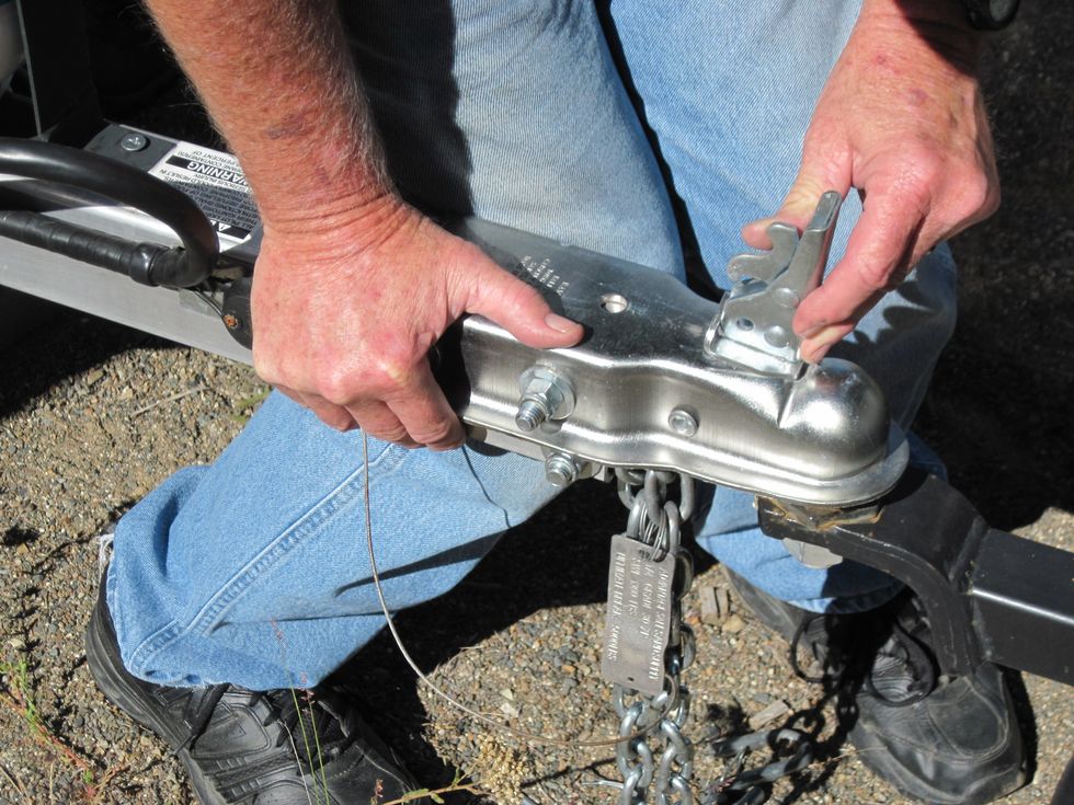 Now jiggle the lever down to lock the hitch onto the ball. See how my left thumb is pressing a little lever to open the hitch up to accept the ball.