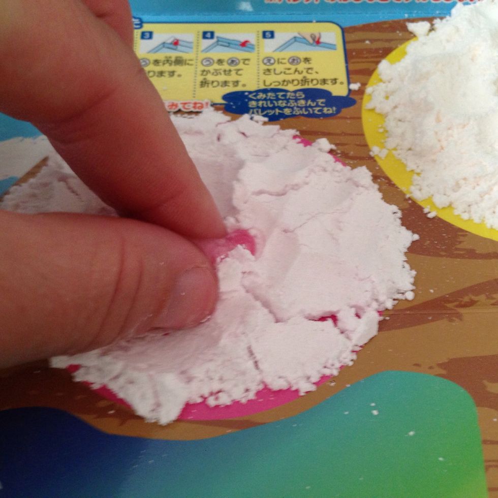 Now just take your fingers and pinch and keep folding the powder into the water until all of your powder is pink and moist