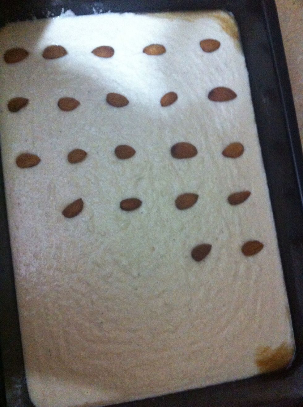 Now keep almonds at equal distance on the batter in a way that every square that we cut out of it, gets one almond