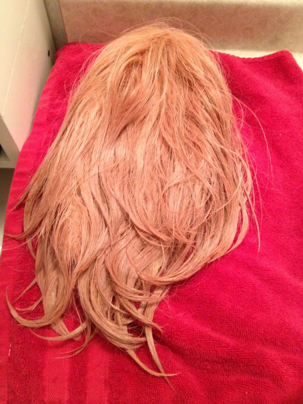 Now lay it out on the towel to air dry. Make sure the surface is flat and the wig is out of direct sunlight. If the wig is curly, scrunch the curls up every so often so they don't lose their bounce.