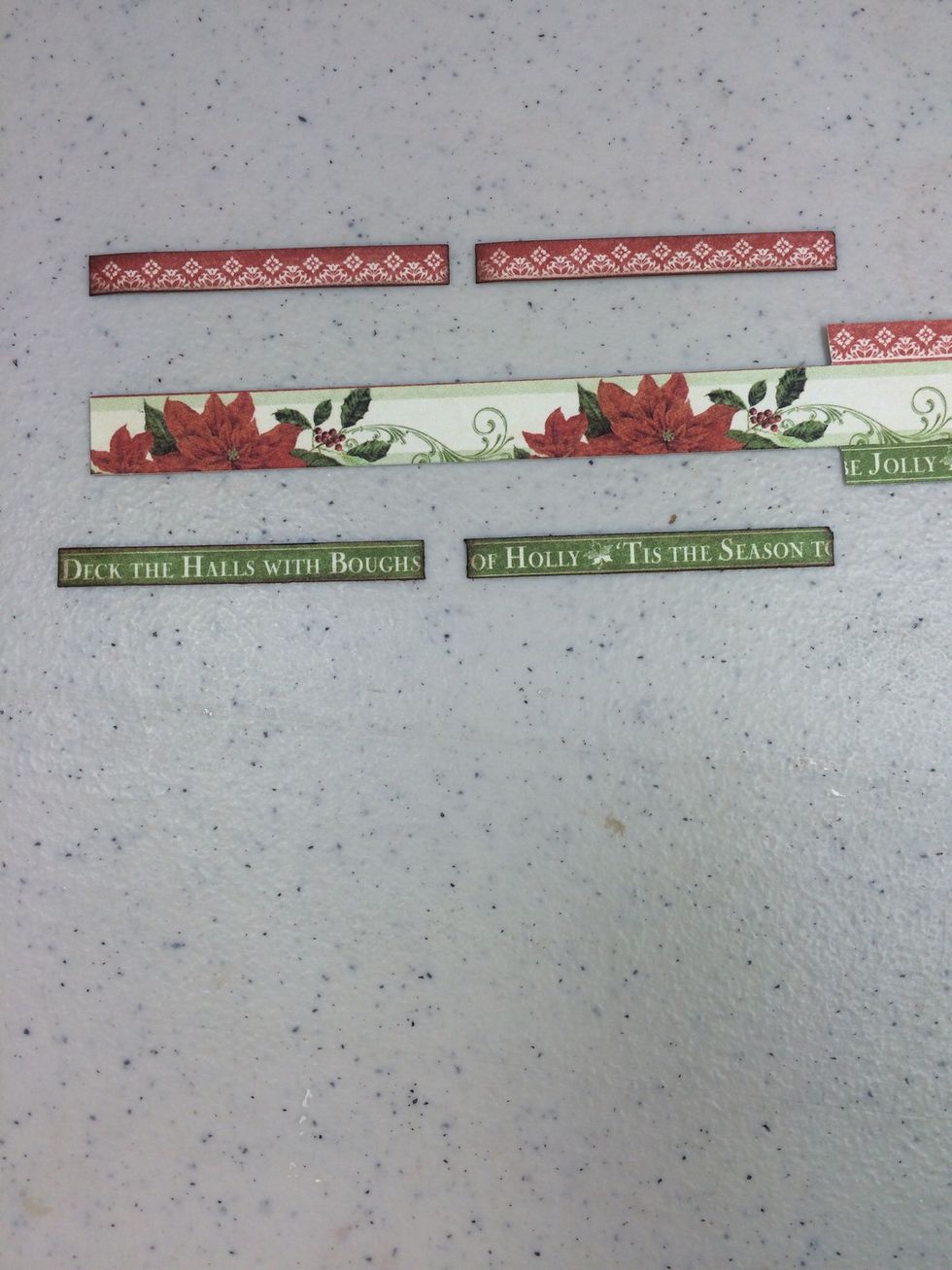 Now let's make 4 tags. Cut away two green strips from the December border piece at 2 1/4" long each. Do the same with two red pieces.