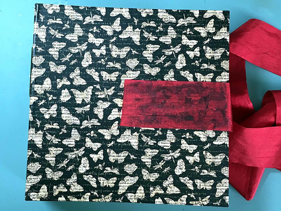 Now let's put this all together! Cut 2 pieces of ribbon 18". Glue to the cover centering top to bottom. I used glue on the cover & you can see that it shows thru the ribbon, (con't next page)