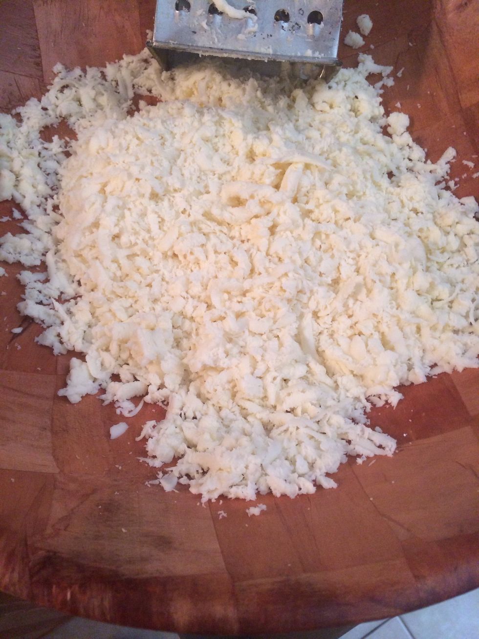 Now let's work on the filling, shred the mozzarella. TIP: stick the mozzarella in the freezer for about 15-20. Remove and shred it.