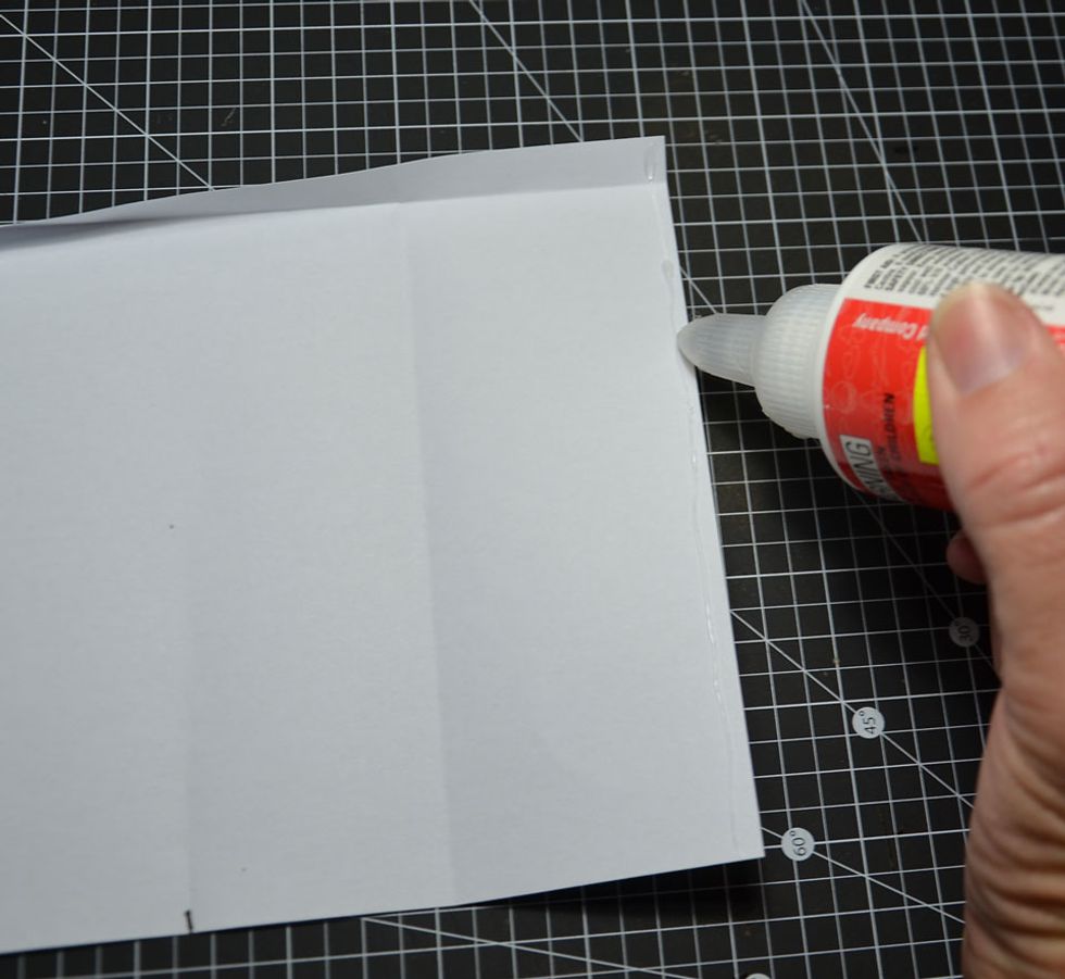 Now lift top folded flap run glue down the entire right side edge as shown.