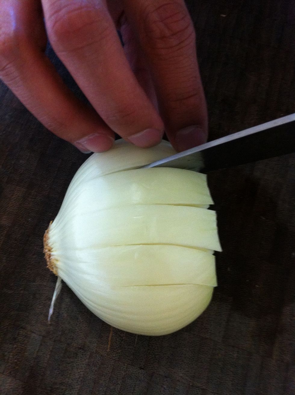Now make a few vertical cuts, equal distance apart. Only cut about 3/4 the length of the onion so it still holds itself together. The more cuts you make, the smaller the dice.