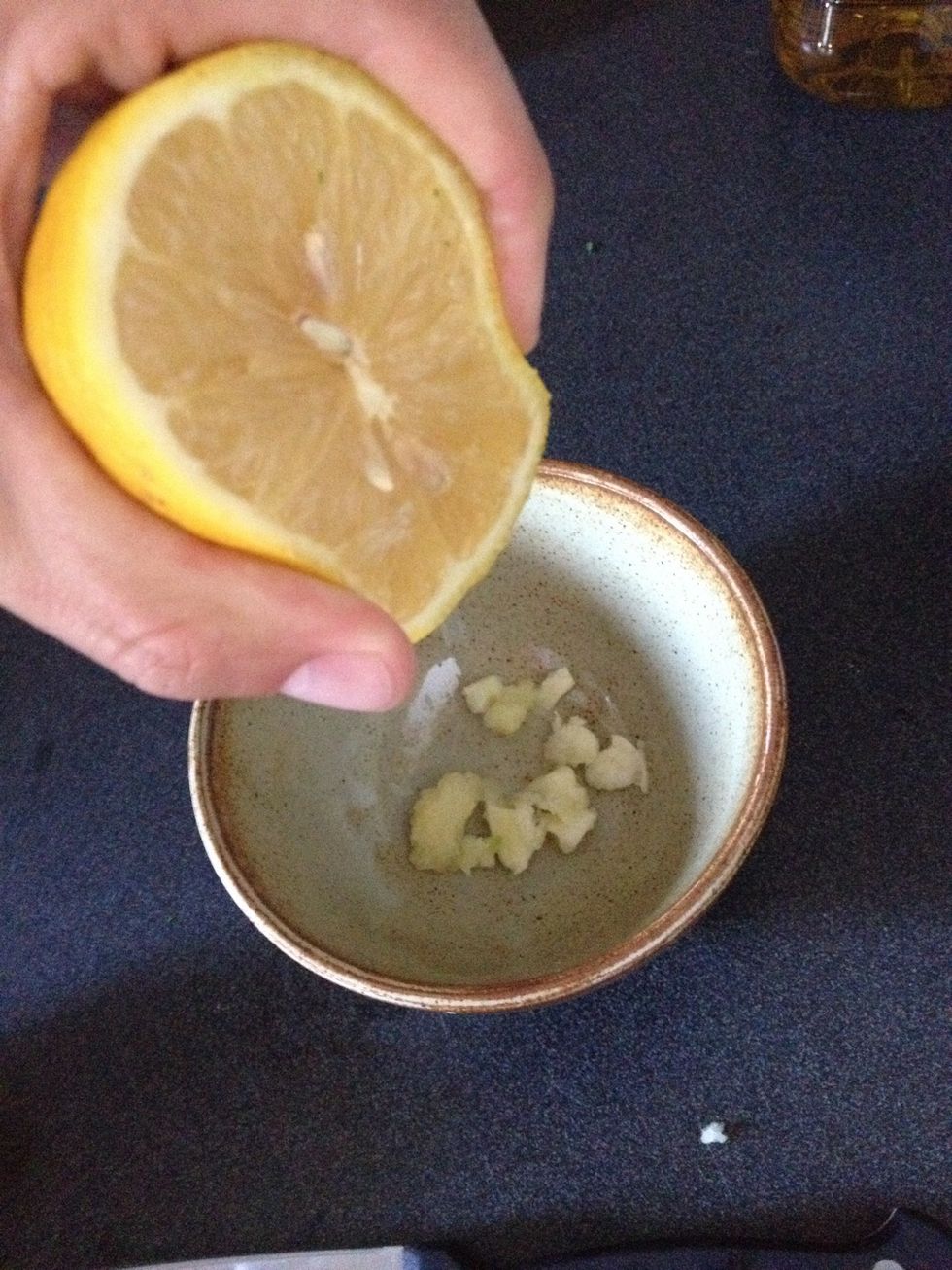 Now make the lemon vinaigrette. Add lemon juice and crushed garlic to a small bowl. Then add a teaspoon of Dijon.