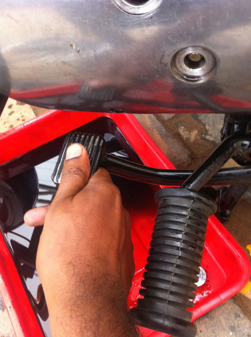 Now oil will start oozing out from the case. To get better access you can press the brake lever and lock it in that position