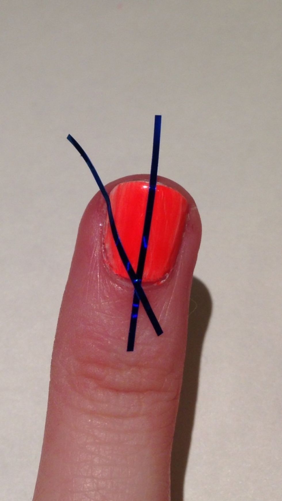 Now on both sides of your first piece of tape you will put a piece of tape diagonally so it touches the side of your nail. Do this on both sides.