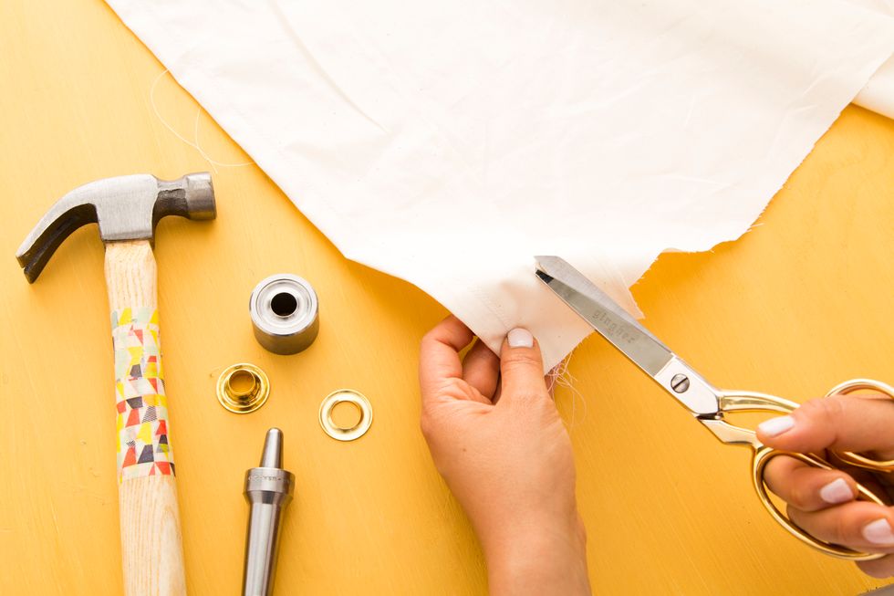 Now onto the grommets! Cut a small X two inches in on all four edges. This leaves enough room to hem any edges that haven't been hemmed yet.