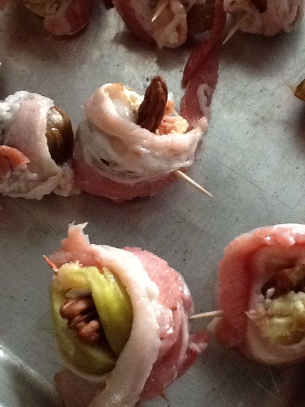 Now place a pecan in the top of each fig. The goat cheese helps to hold on to each pecan, so push the pecan in the goat cheese.