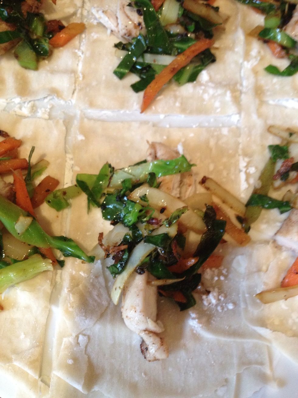 Now place a piece of your cooked chicken in the middle of each square and then spoon over some of the stir fried vegetables.