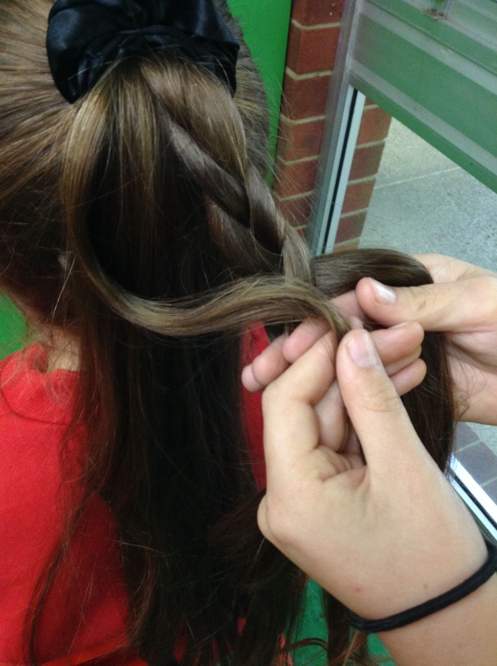 Now plait your way down three and grab a bit of hair from your pony tail and join it into the last separated bunch of plait.