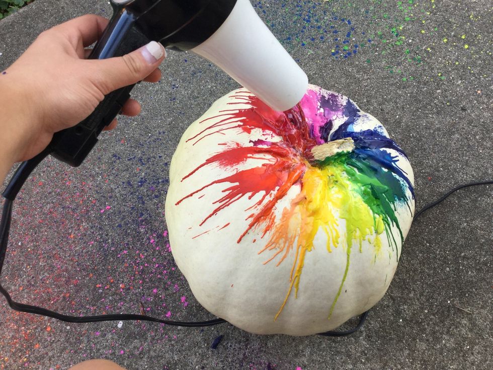Now plug in your hair dryer and turn it on. Start blowing downwards from the stem of your pumpkin, pointing the hair dryer towards the direction you want your colors to drip.