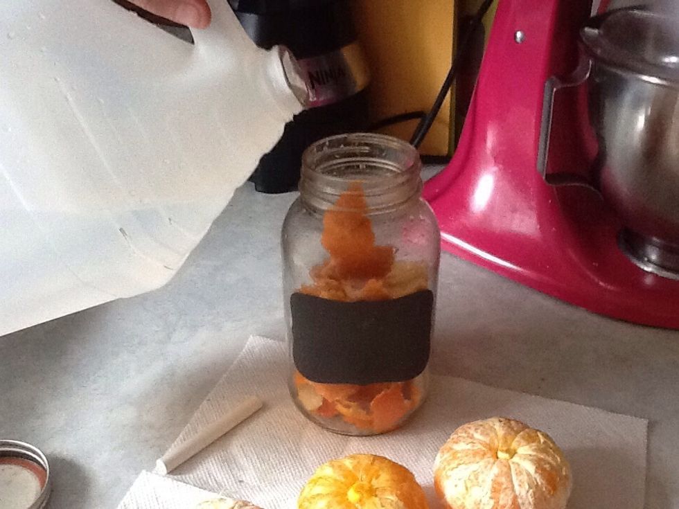 Now pour vinegar over peels. Cover them and even add a bit extra so they can't dry out. Any amount of vinegar works with any amount of oranges. This is a basic cleaner that you can customize yourself