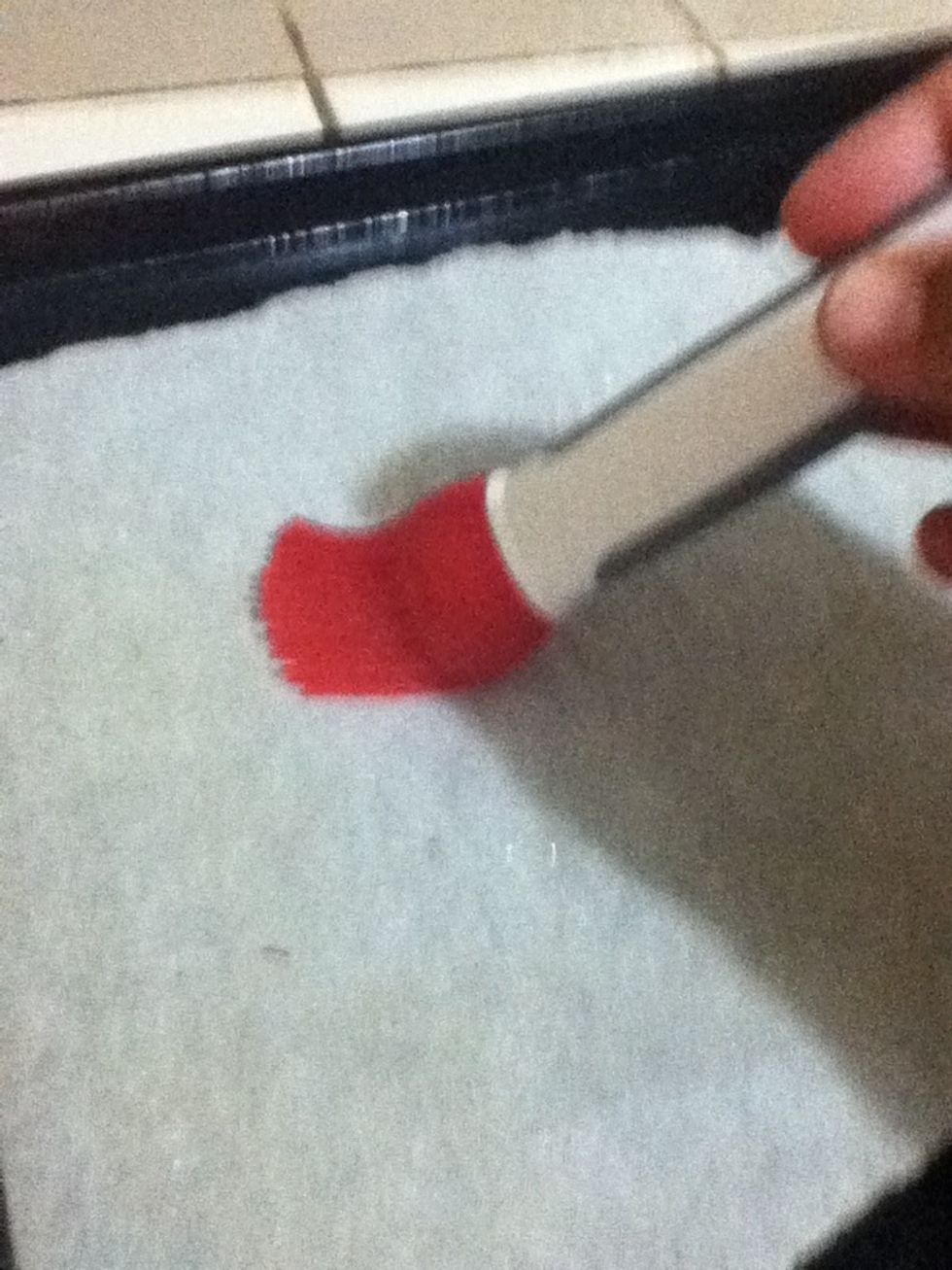 now prep the cookie sheet by lining it with parchment paper, and brush with light oil.