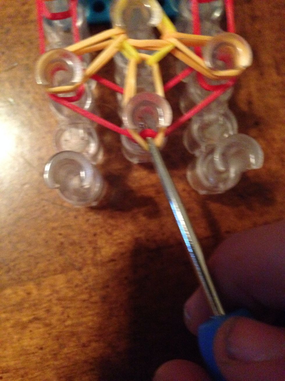 Now pull back the first orange rubber band and grab your first red rubber band