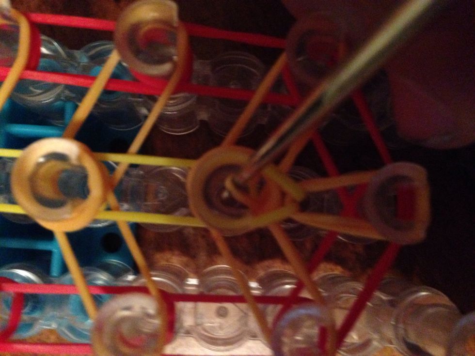 Now pull back the next cap band and hook on to the first orange rubber band