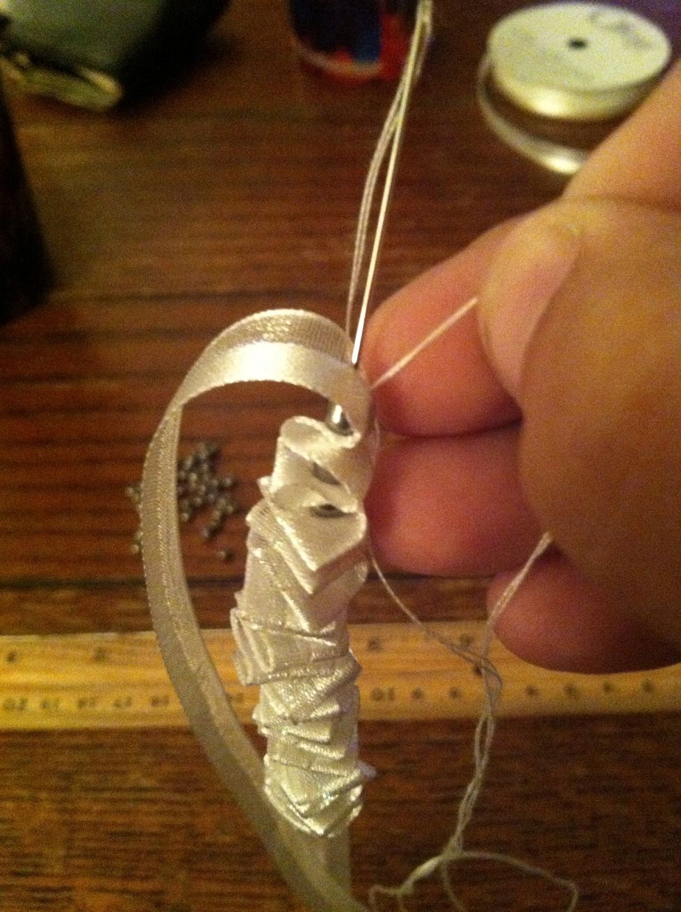 Now pull the needle all the way through, make it tight, then insert your needle back through, you're going to go through all the beads again for strength.