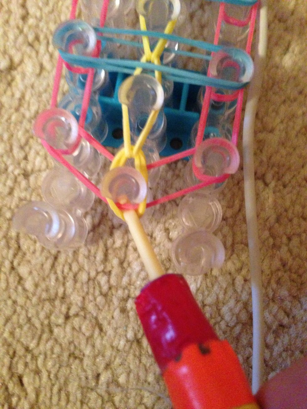 Now pull the yellow band back and hook the first pink band