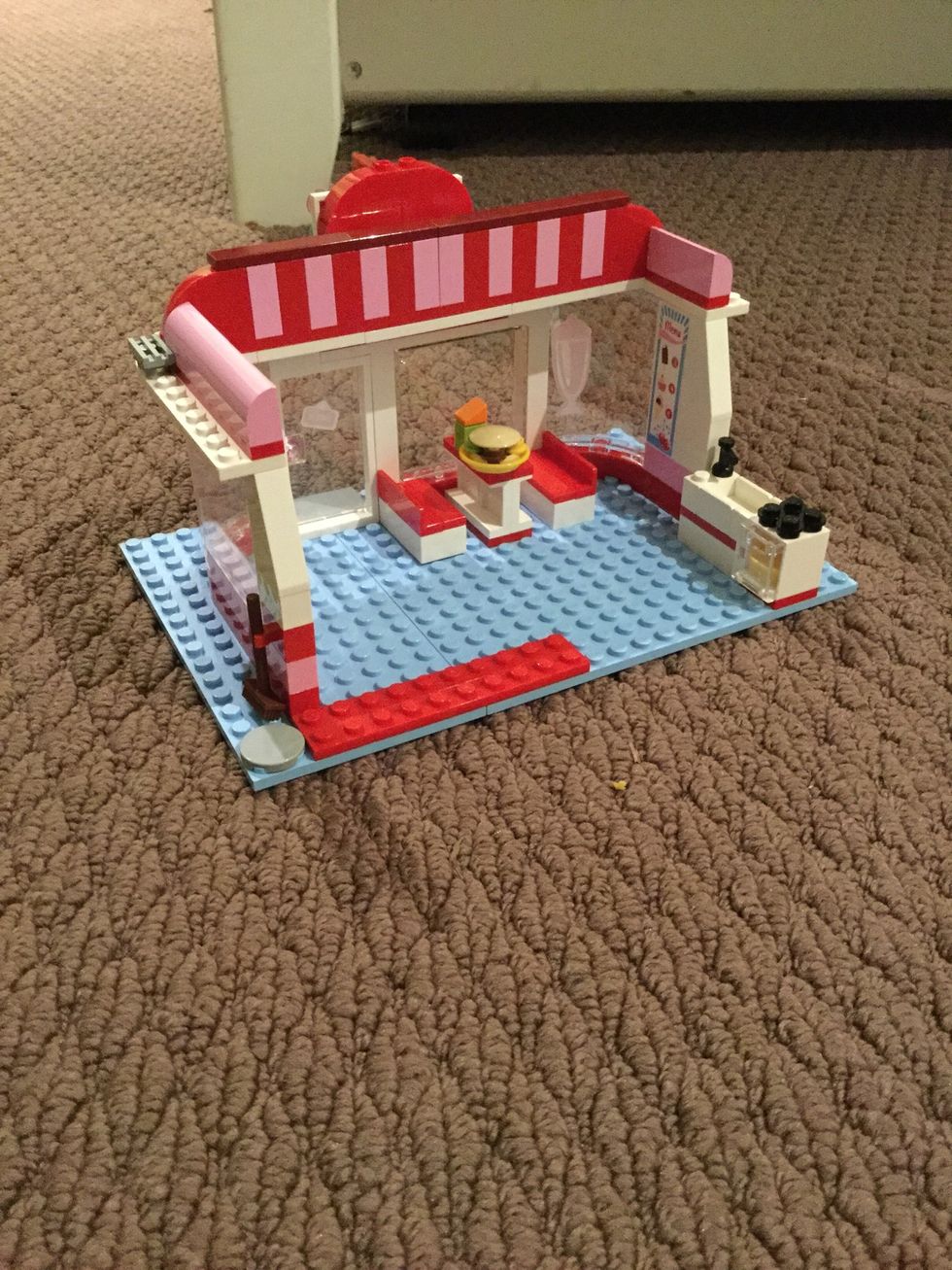 Now put the burger and the juice on the table and the broom on the left side of the cafe in the red holder.