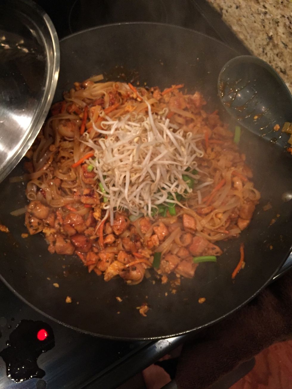 Now, reduce heat down to low. Add the bean sprouts and green onion. Do not let them touch the wok, just set them in the middle and fold them in so they steam. This will prevent them from cooking down.