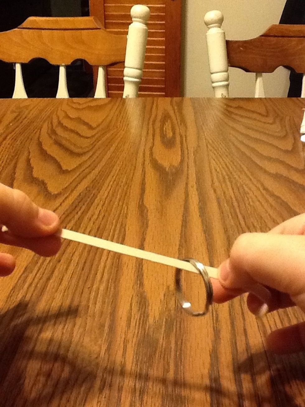 Now release the excess rubber band to magically make the ring climb the rubber band