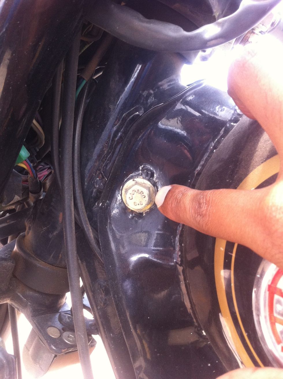 Now remove these 14mm bolts that secure the tank in its place. This is the one in the front.