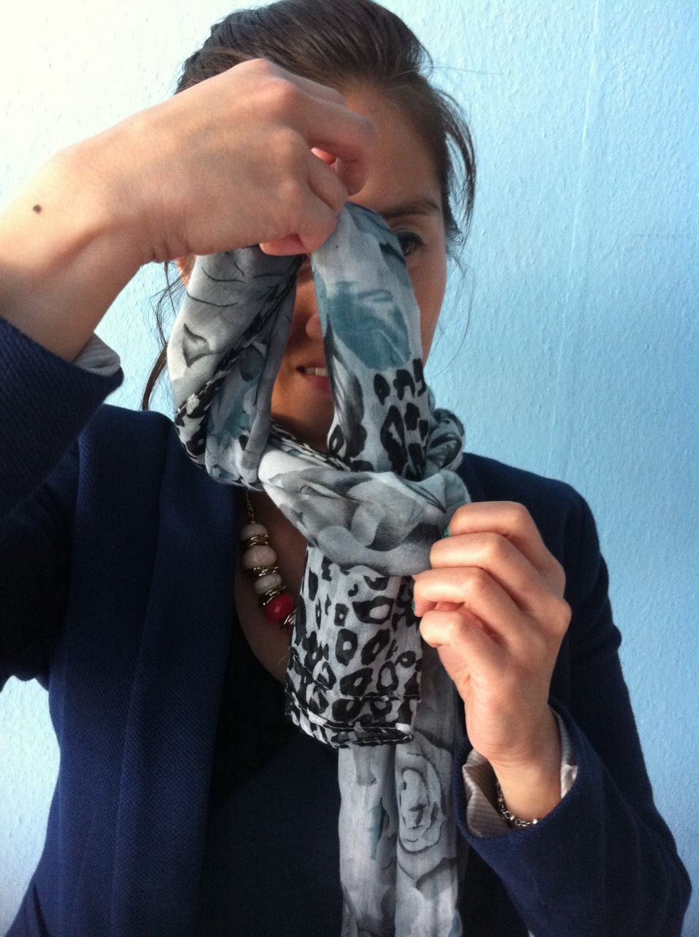 Now repeat again: put one side into the gap of the scarf...