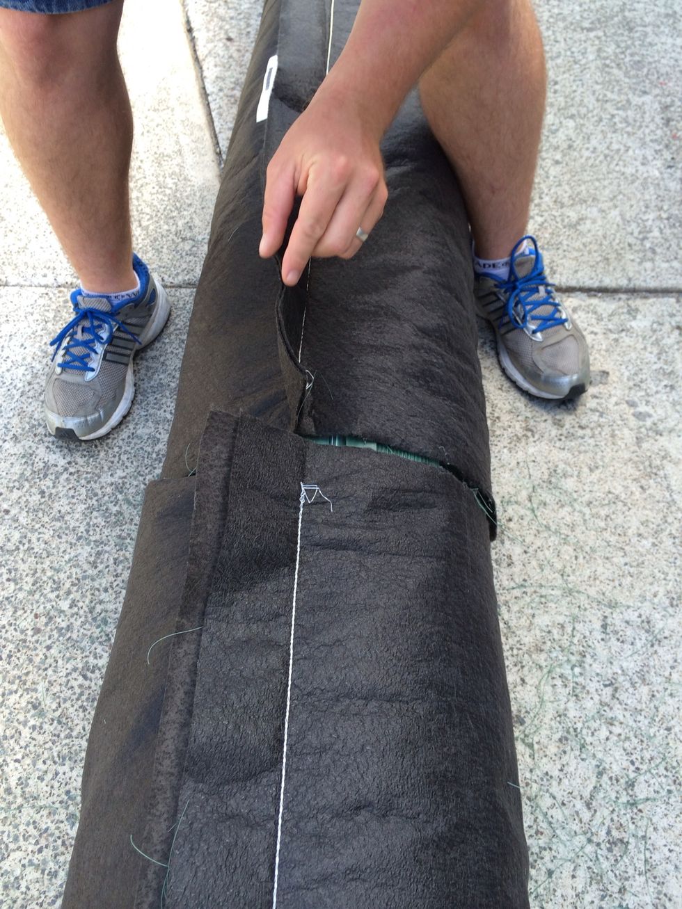 Now roll the fabric, bio accelerator and fibres back over the AES coupling. Seams are always laid at the top when they are back filled with system sand.